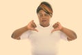 Studio shot of fat black African woman giving thumbs down ready for gym Royalty Free Stock Photo