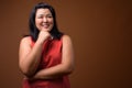 Happy beautiful overweight Asian woman thinking and smiling