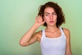 Studio shot of beautiful teenage girl thinking while listening a Royalty Free Stock Photo