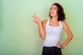 Studio shot of beautiful teenage girl thinking while looking and Royalty Free Stock Photo