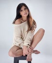 Au-natural.... Studio shot of a beautiful young brunette woman sitting on a stool. Royalty Free Stock Photo