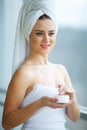 Studio shot of beautiful young woman applying moisturizer cream Royalty Free Stock Photo