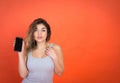 Studio shot of a beautiful young woman looking on camera while using cell phone Royalty Free Stock Photo