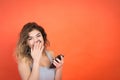 Studio shot of a beautiful young woman looking on camera while using cell phone Royalty Free Stock Photo