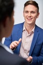 Studio Shot Of Businessman Interviewing Businesswoman For Employment Against White Background