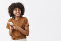 Studio shot of carefree friendly and creative stylish african american teenage girl in brown t-shirt turning right with Royalty Free Stock Photo