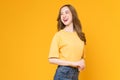 Studio shot of cheerful beautiful Asian woman in t-shirt and stand on yellow background