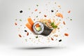 Studio shot, close up of delicious sushi roll with avocado, salmon, cucumber and seeds, ingredients falling isolated on white