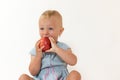 Studio shot of cool toddler girl eating red apple Royalty Free Stock Photo