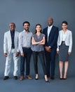 We here for the opportunity. Studio shot of corporate businesspeople posing against a gray background.