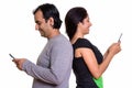 Happy Persian couple smiling while using mobile phone together b Royalty Free Stock Photo
