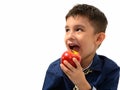 Studio shot of cute happy boy smiling and eating apple while thi Royalty Free Stock Photo