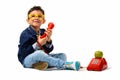 Studio shot of cute happy boy smiling and holding old telephone Royalty Free Stock Photo
