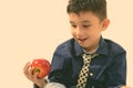 Studio shot of cute happy boy smiling and holding red apple Royalty Free Stock Photo