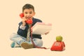 Studio shot of cute happy boy smiling while talking on old telephone and giving gift box Royalty Free Stock Photo