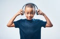 When I grow up I want to be a DJ. Studio shot of a cute little boy using headphones against a grey background. Royalty Free Stock Photo