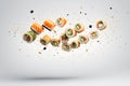 Studio shot of delicious sushi rolls with avocado, salmon, cucumber and seeds, slices and ingredients falling on white background Royalty Free Stock Photo