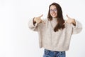 Studio shot of delighted charismatic happy girl in glasses pointing at herself for friend check out new awesome sweater Royalty Free Stock Photo