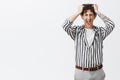 Studio shot of depressed young guy with moustache in striped shirt losing temper screaming out loud pulling hair out of Royalty Free Stock Photo