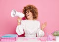 Studio shot of emotional office woman with Afro hair holds megaphone and screams loudly, wears eyeglasses and official Royalty Free Stock Photo