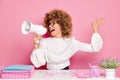 Studio shot of emotional office woman with Afro hair holds megaphone and screams loudly, wears eyeglasses and official Royalty Free Stock Photo