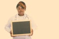 Studio shot of fat black African woman doctor thinking while holding blank blackboard Royalty Free Stock Photo