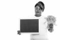 Studio shot of fat black African woman thinking while holding lettuce and blank blackboard Royalty Free Stock Photo