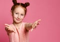 Studio shot of a friendly cute redhead little girl pulling hands towards