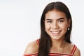 Studio shot of good-looking indian teenage girl in blouse and earrings smiling joyfully and gazing at camera friendly Royalty Free Stock Photo