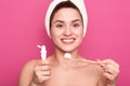 Studio shot of good looking young woman holding brush and tooth paste for teeth cleaning in hands. happy smiling girl with Royalty Free Stock Photo