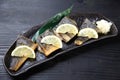 Studio shot of grilled atka mackerel with lemon on dark background