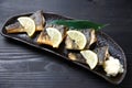 Studio shot of grilled atka mackerel with lemon on dark background