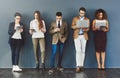 Wireless entertainment for the wait. Studio shot of a group of businesspeople using wireless technology while waiting in Royalty Free Stock Photo