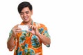 Young happy Asian man smiling and taking picture with mobile pho Royalty Free Stock Photo
