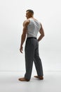 Studio shot of handsome man wearing classic trousers and posing shirtless over white background. Side view Royalty Free Stock Photo