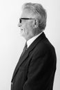 Profile view of happy senior bearded businessman smiling while wearing eyeglasses against white background Royalty Free Stock Photo