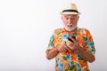 Handsome senior bearded tourist man looking shocked while using phone