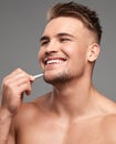 Keeping it tight around the edges. Studio shot of a handsome young man plucking his beard against a grey background. Royalty Free Stock Photo