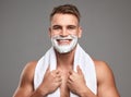 Gotta look good for my date. Studio shot of a handsome young man with shaving foam on his beard against a grey Royalty Free Stock Photo