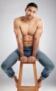 Fitness is my passion. Studio shot of a handsome young man showing off his muscular body while sitting on a chair Royalty Free Stock Photo