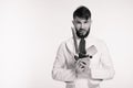 Studio shot of a happy bearded young chef holding sharp knives over white background. Chef with knife. Handsome angry serious chee Royalty Free Stock Photo