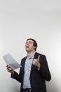 Studio shot of happy businessman celebrating a paper Royalty Free Stock Photo