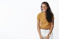 Studio shot of happy carefree charismatic african american female with cool tattoo closing eyes as laughing and smiling