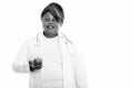 Studio shot of happy fat black African woman doctor smiling and thinking while holding apple Royalty Free Stock Photo