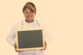 Studio shot of happy fat black African woman doctor smiling and thinking while holding blank blackboard Royalty Free Stock Photo