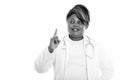 Studio shot of happy fat black African woman doctor smiling and thinking while pointing finger up Royalty Free Stock Photo