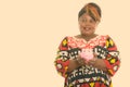 Studio shot of happy fat black African woman smiling and holding piggy bank while thinking Royalty Free Stock Photo