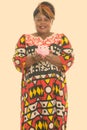Studio shot of happy fat black African woman smiling and standing while holding piggy bank Royalty Free Stock Photo