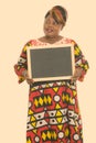 Studio shot of happy fat black African woman smiling while thinking and holding blank blackboard Royalty Free Stock Photo