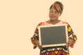 Studio shot of happy fat black African woman smiling while thinking and holding blank blackboard Royalty Free Stock Photo